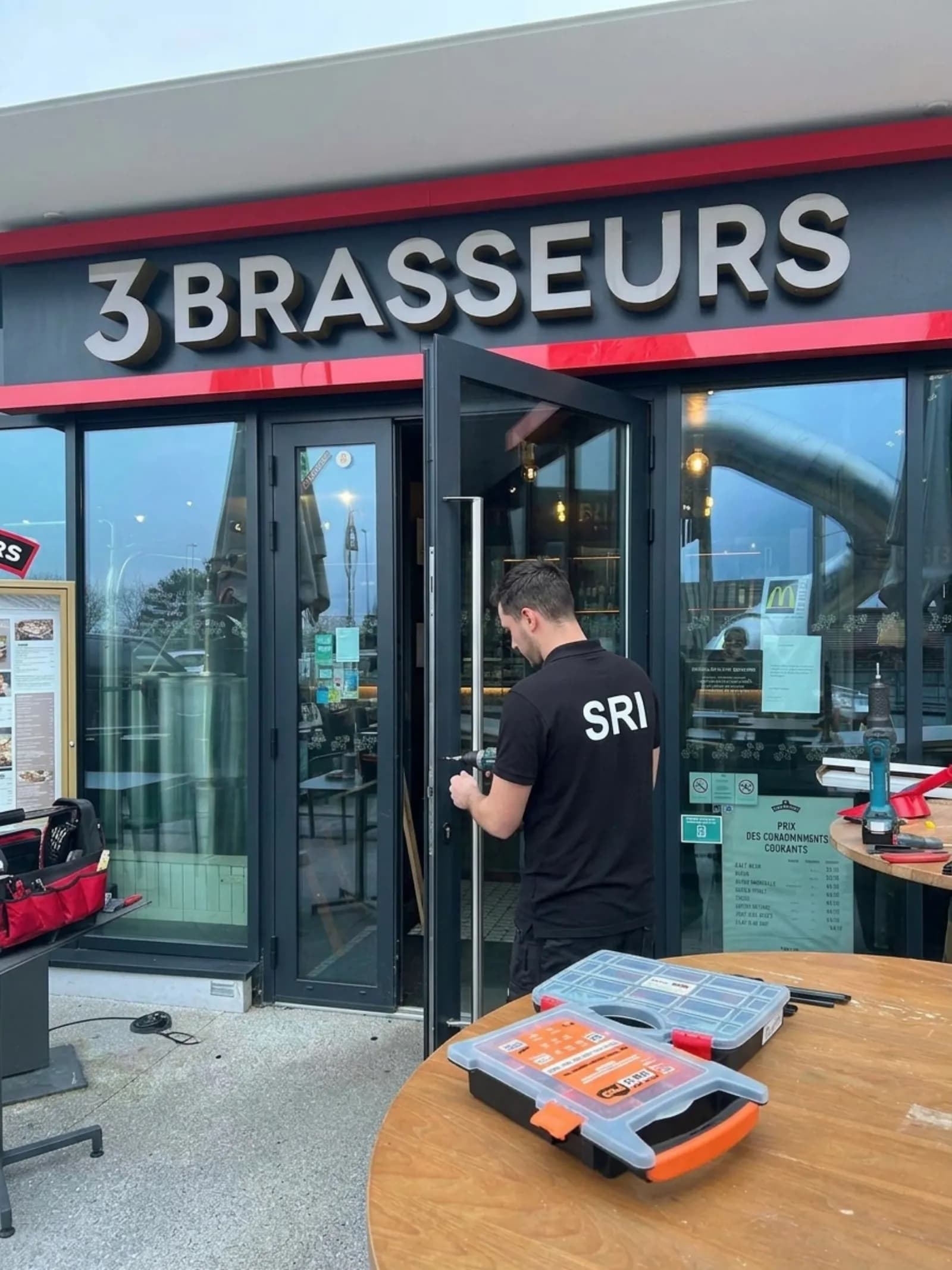 Serrurier SRI intervenant sur la devanture d’un commerce
